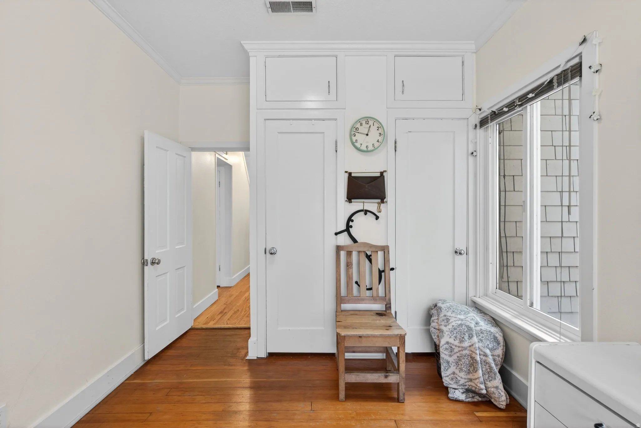 Bedroom with ornamental molding and light wood-style flooring