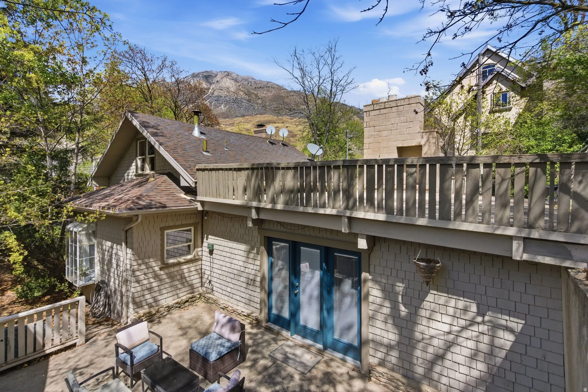 Rear view of property featuring french doors, a mountain view, a patio area, an outdoor hangout area, and a shingled roof