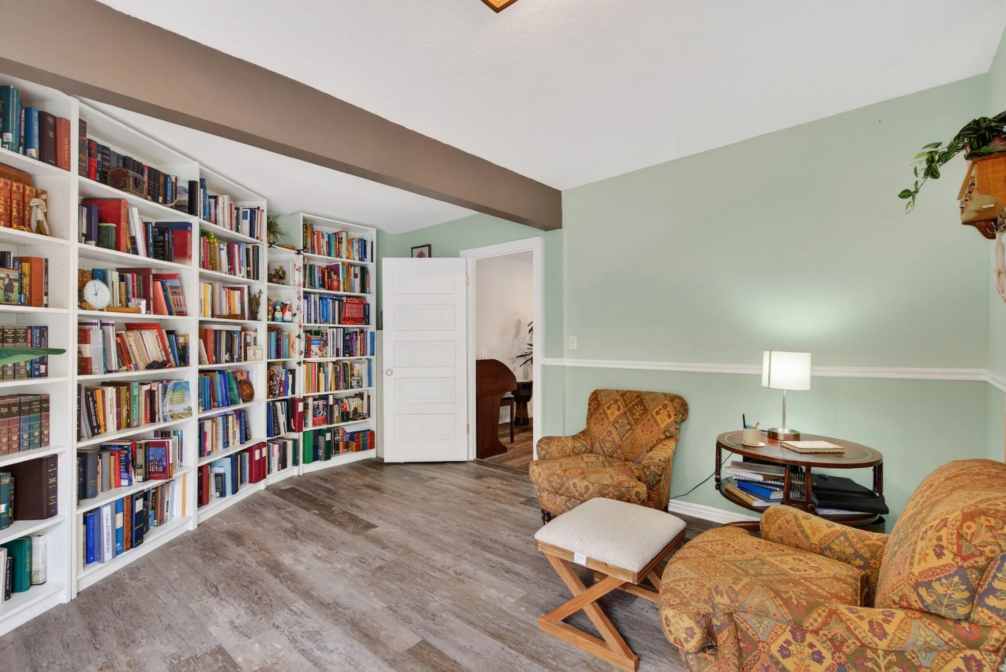 Living area with light wood finished floors and beamed ceiling