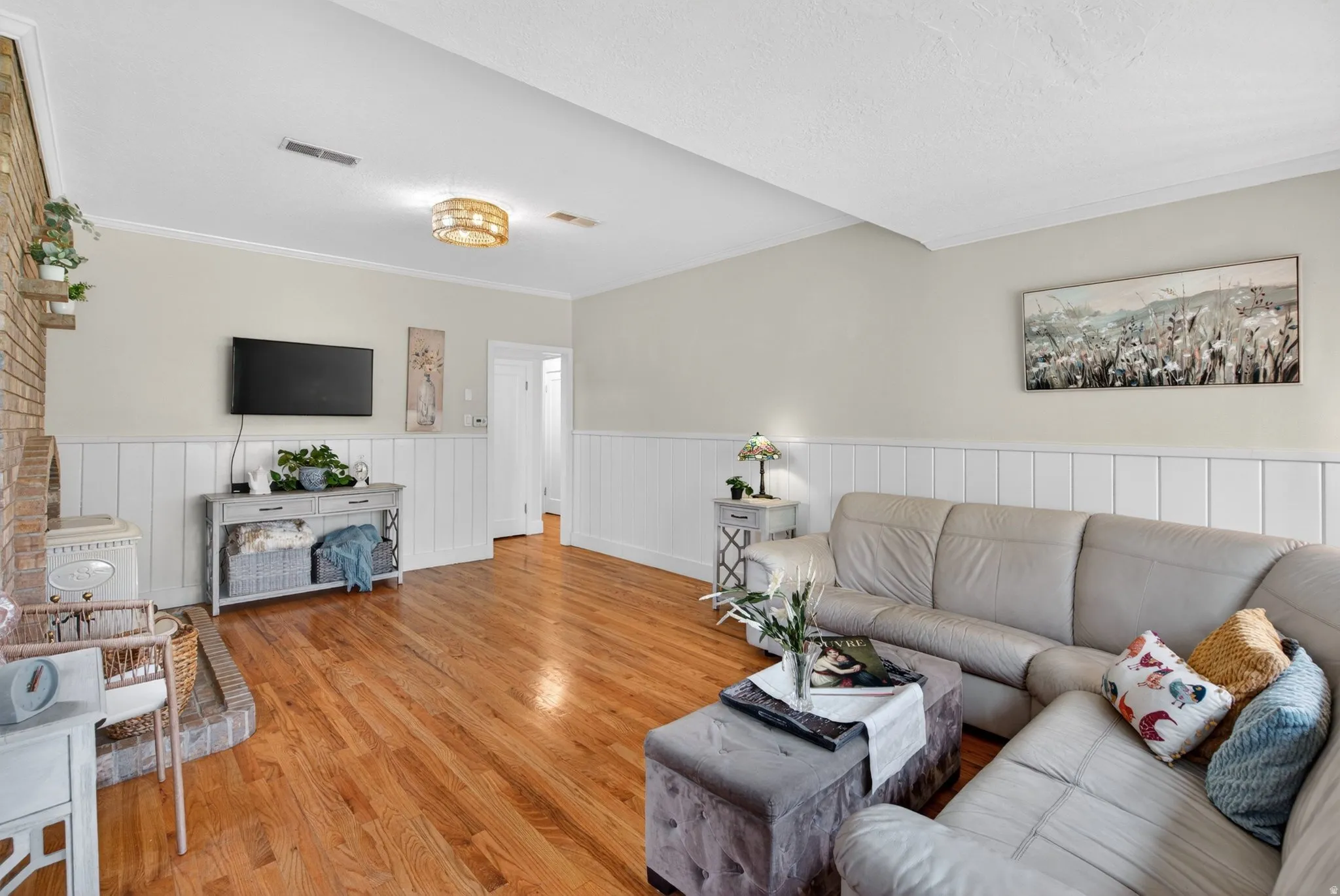 Living room featuring wainscoting, wood finished floors, and ornamental molding