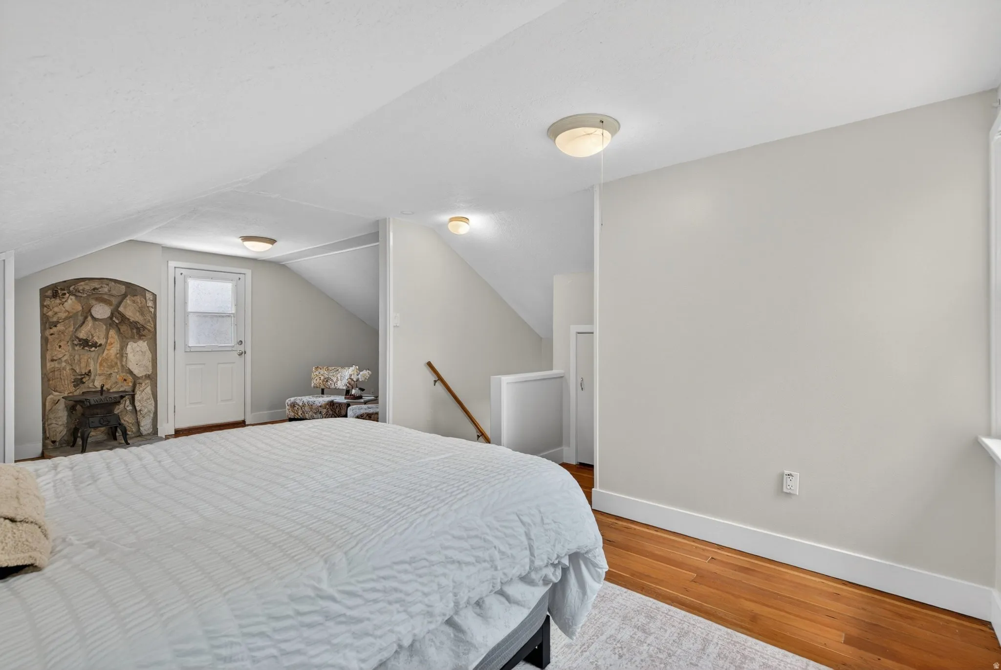 Bedroom featuring light wood-type flooring and vaulted ceiling