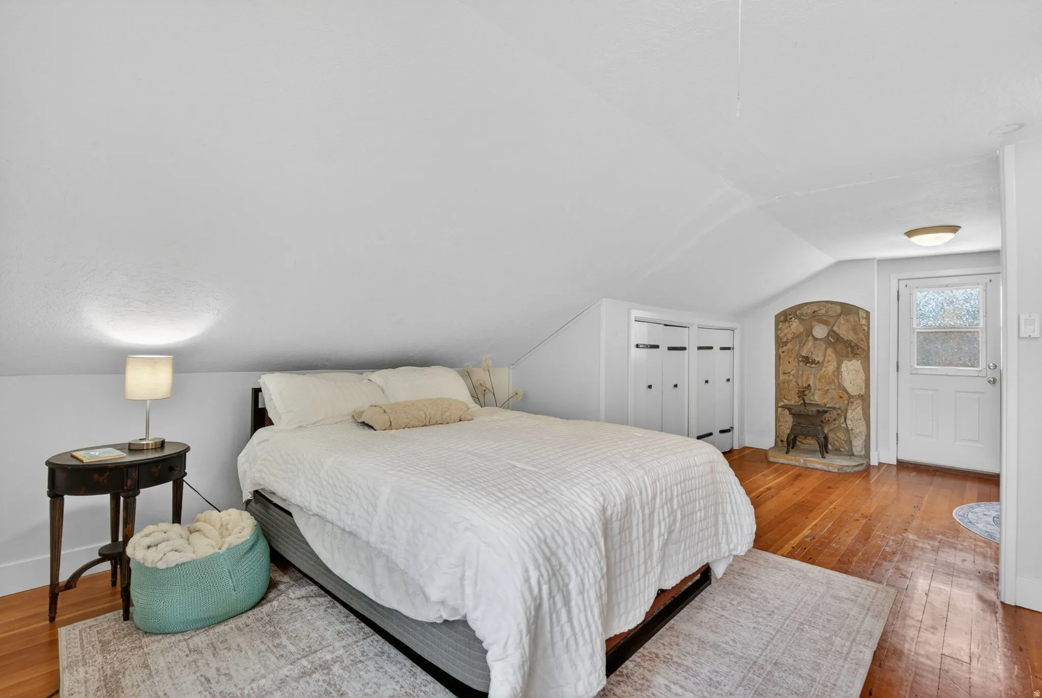 Bedroom with light wood-type flooring, vaulted ceiling, and a closet