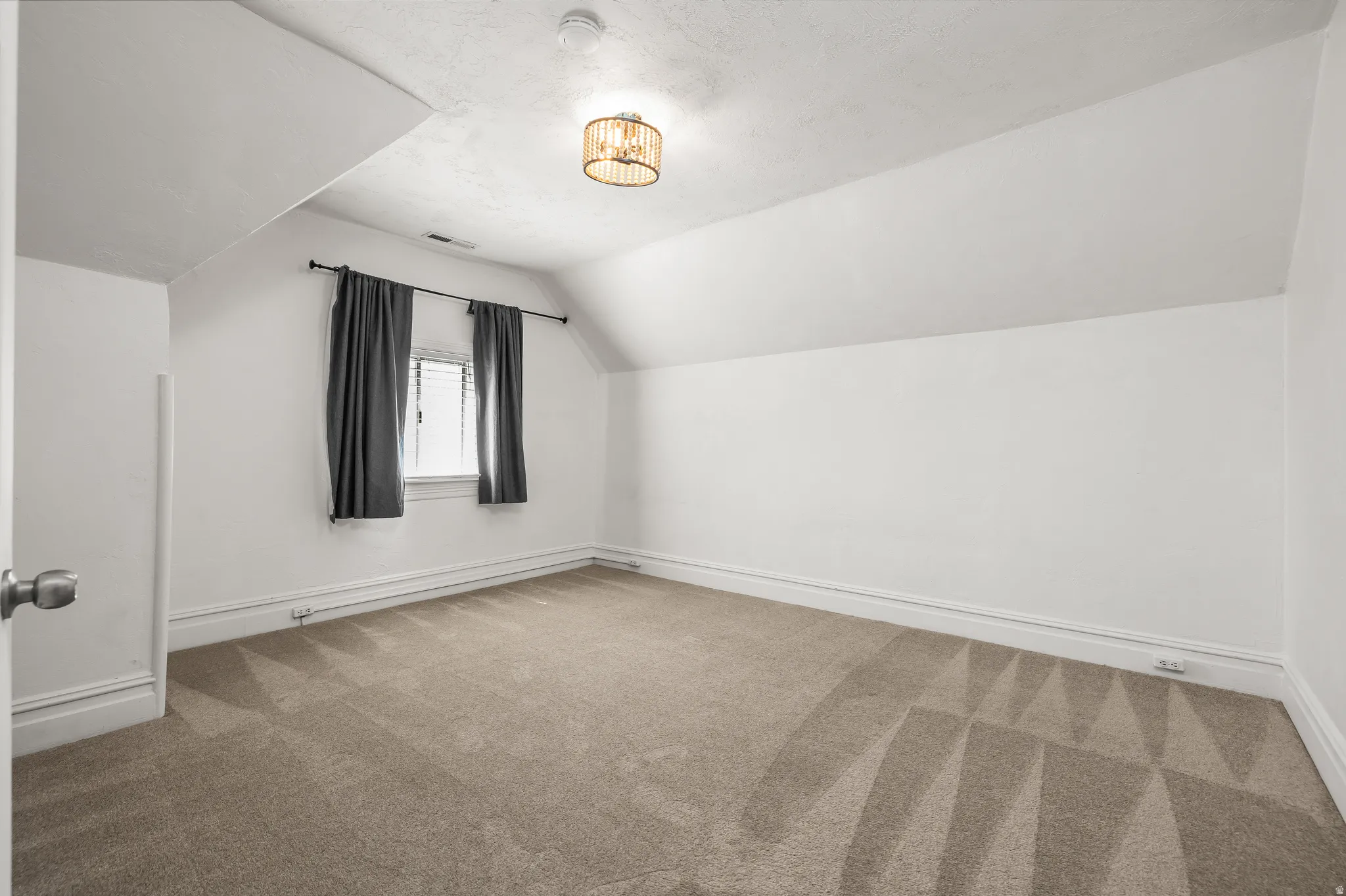 Bedroom 2 featuring vaulted ceiling and carpet floors