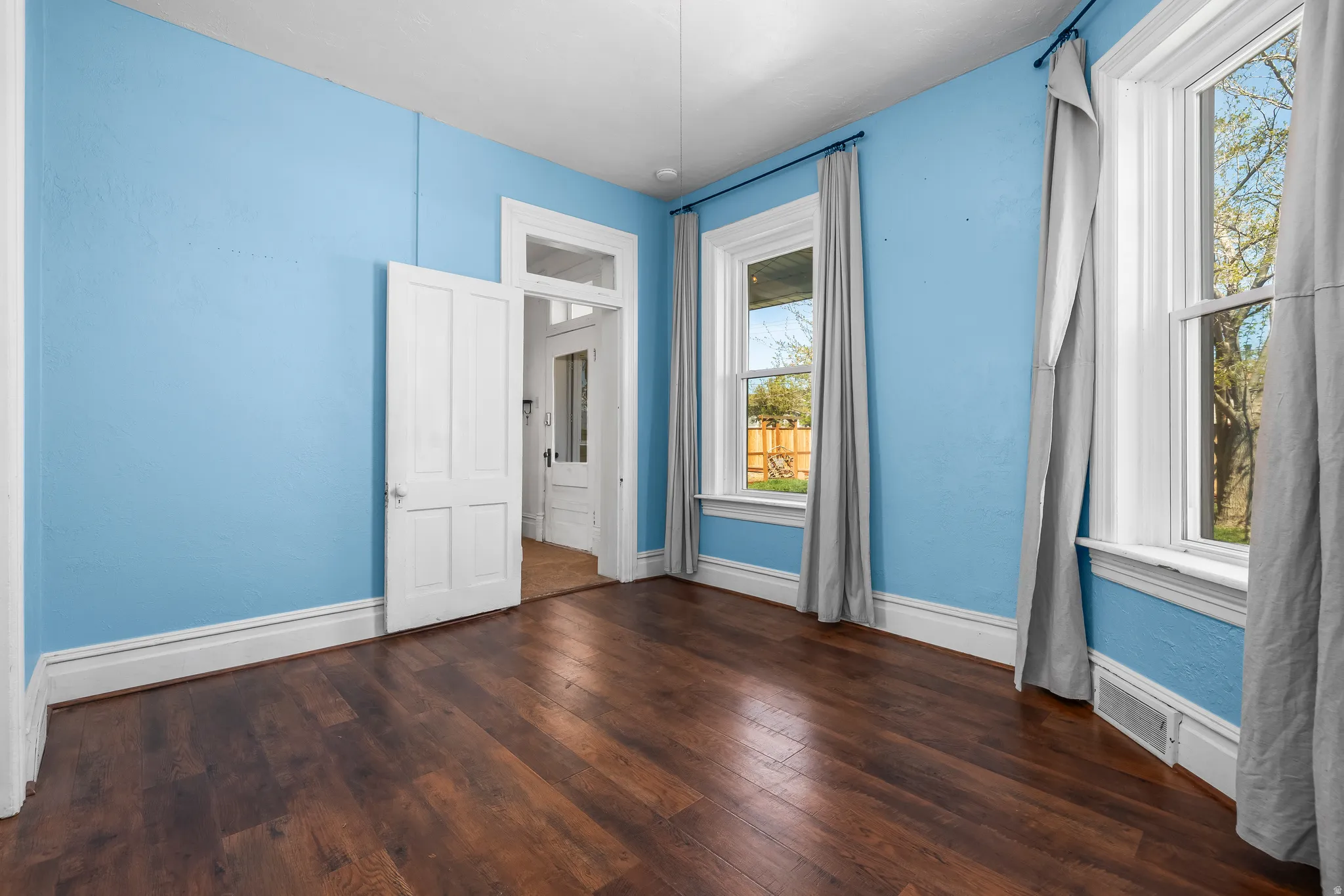 Unfurnished Den/office/Bedroom with dark wood-style flooring and baseboards