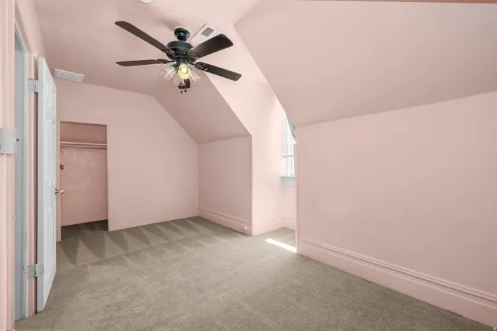 Bedroom 3 with vaulted ceiling, light colored carpet, and ceiling fan