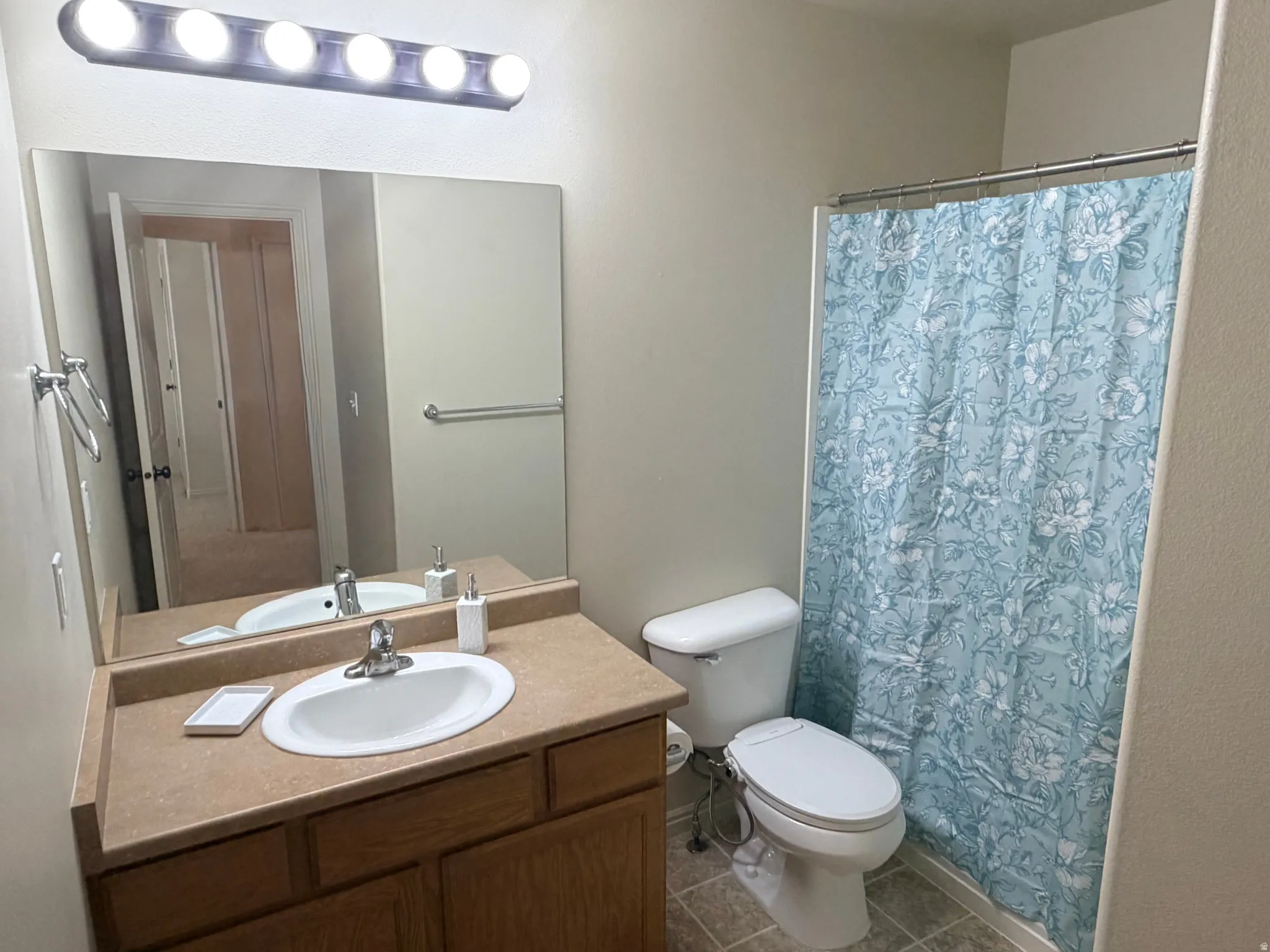 Bathroom featuring vanity, a shower with curtain, and dark tile patterned floors