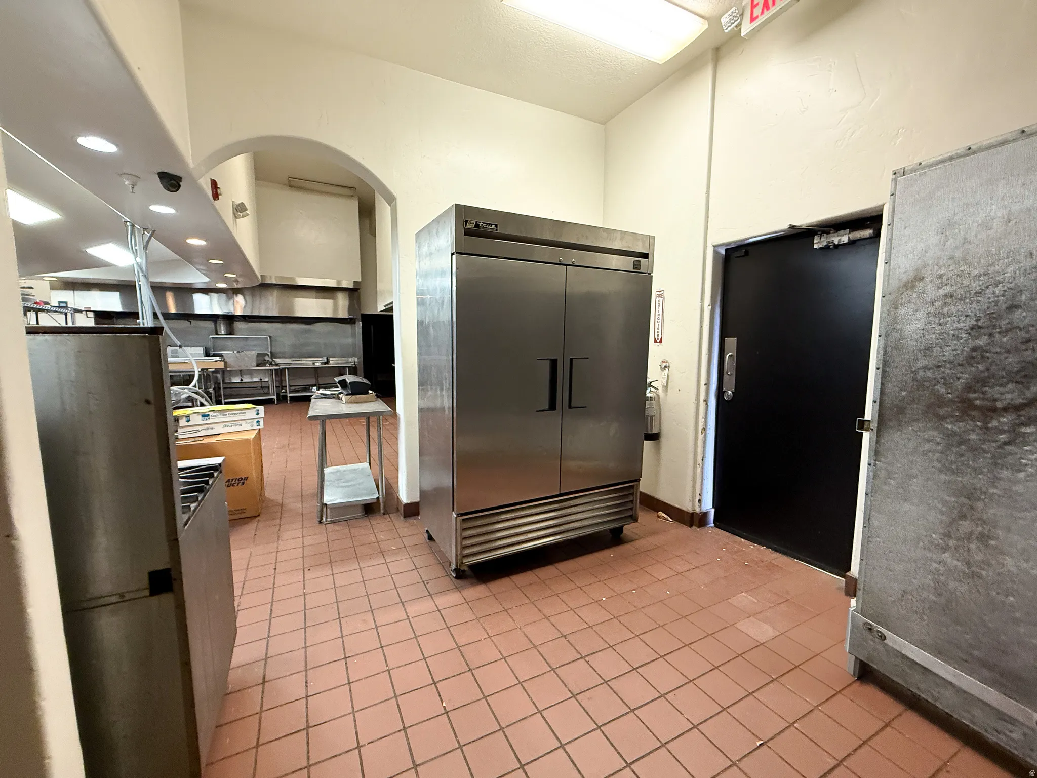 Kitchen with high end fridge, recessed lighting, and arched walkways