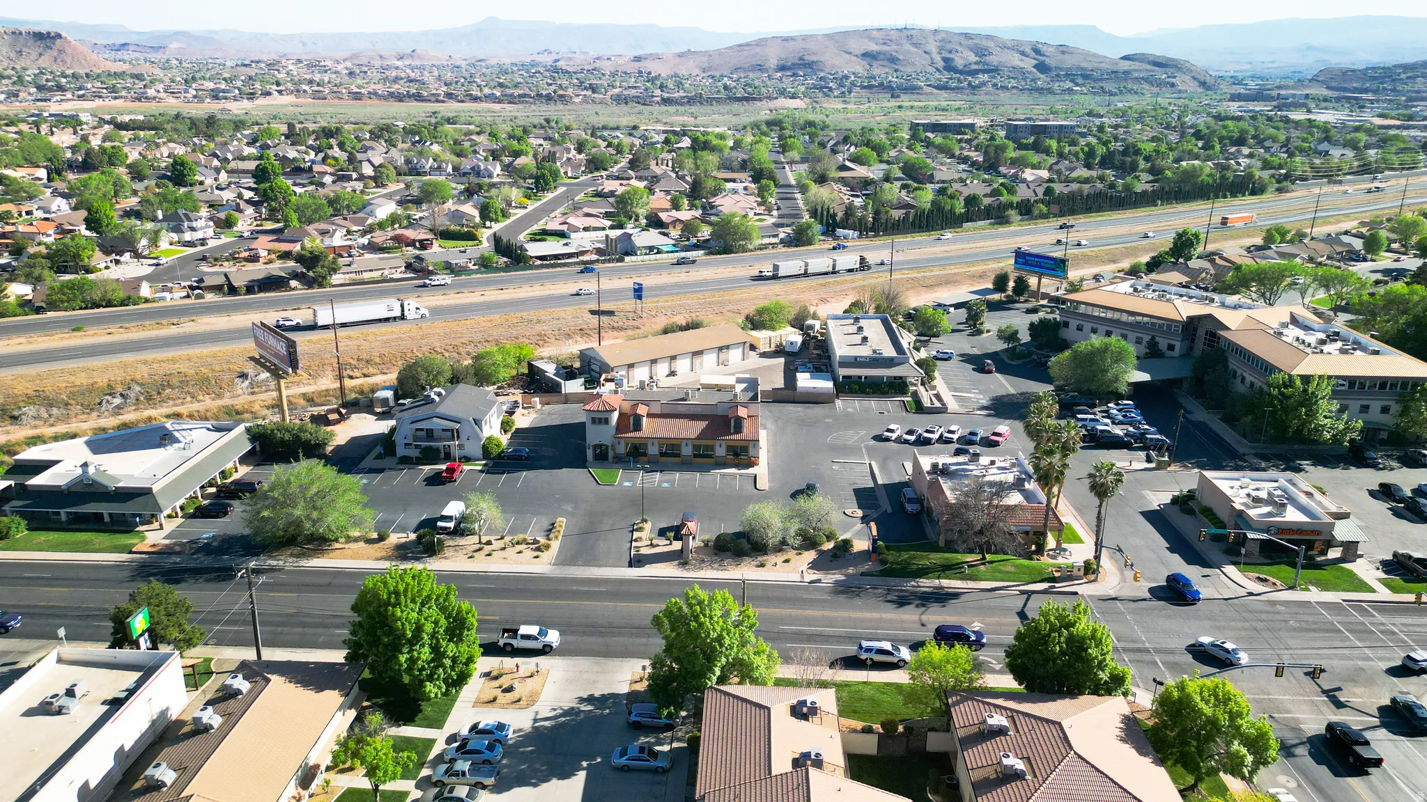 Aerial view of property and surrounding area with a mountain backdrop and nearby suburban area