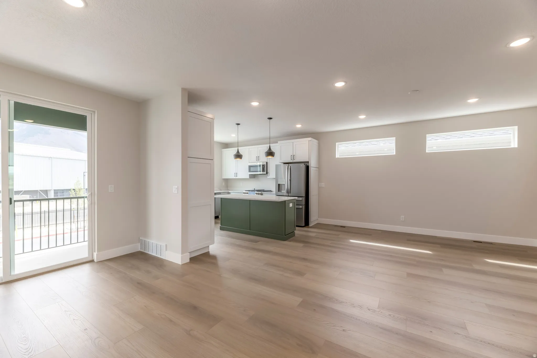 Unfurnished living room featuring light wood-style floors, recessed lighting, and plenty of natural light