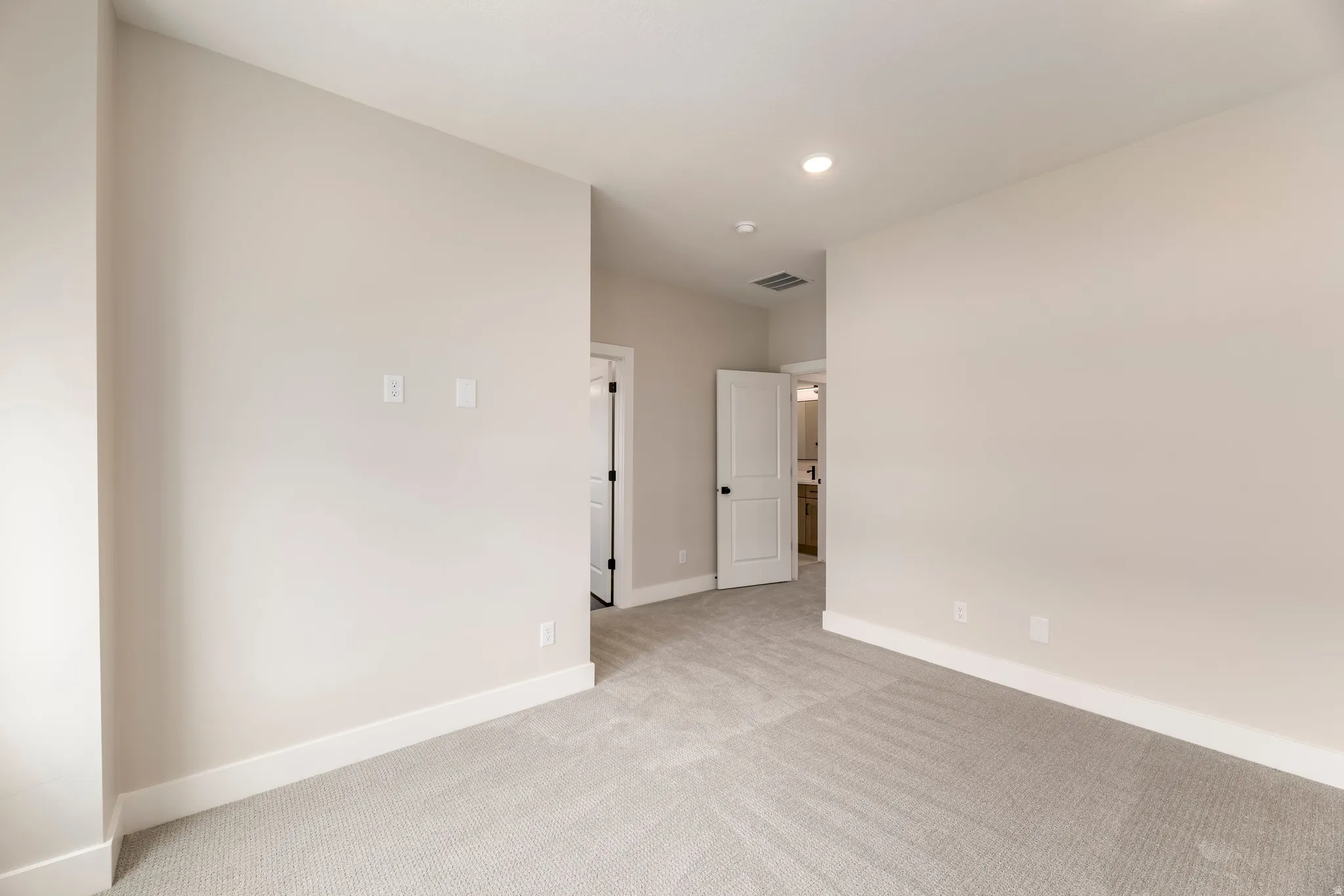 Spare room with light carpet and recessed lighting