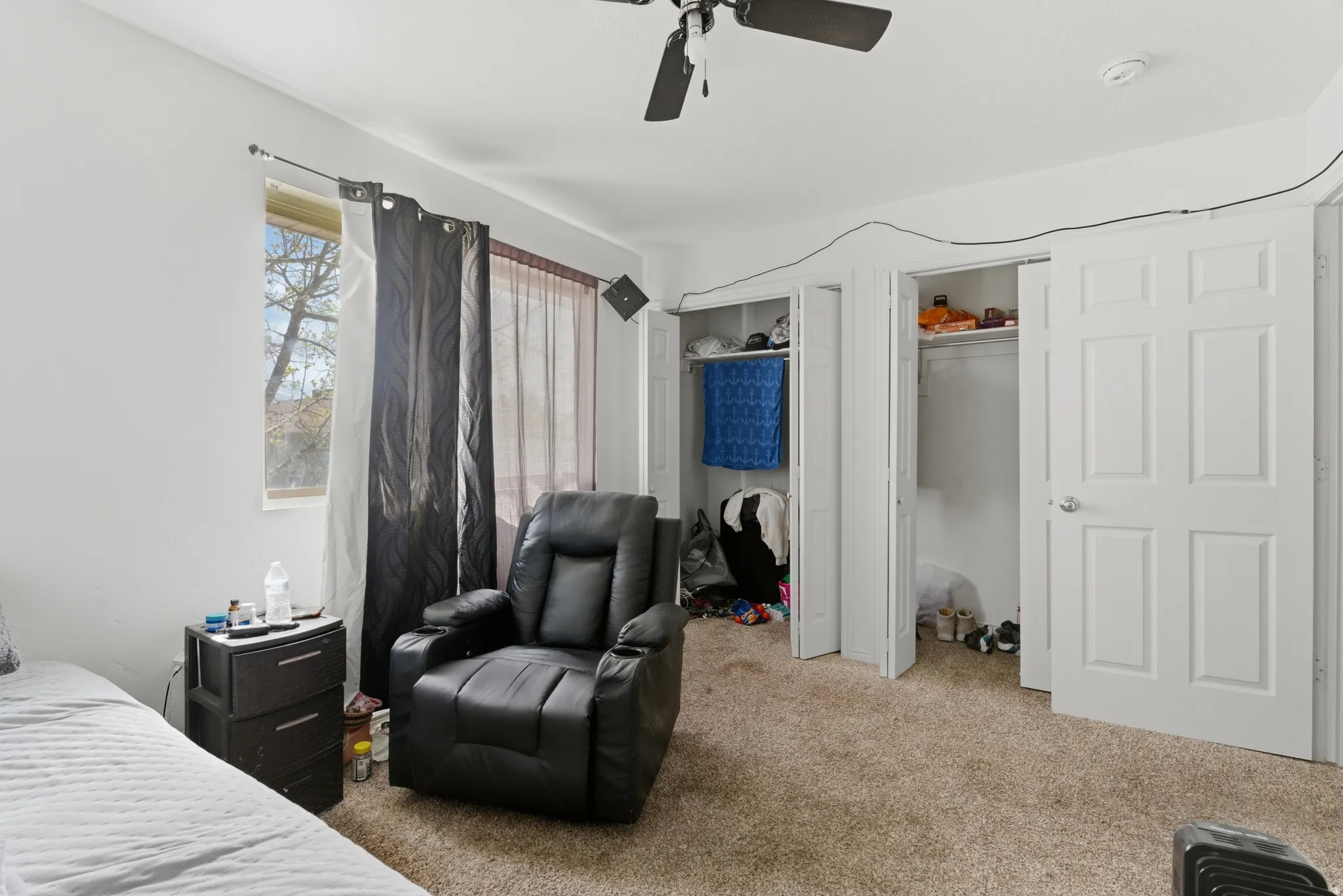 Bedroom featuring two closets, carpet floors, and ceiling fan