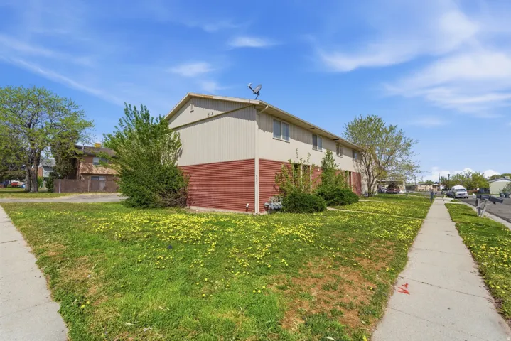 View of property exterior with a yard and a residential view
