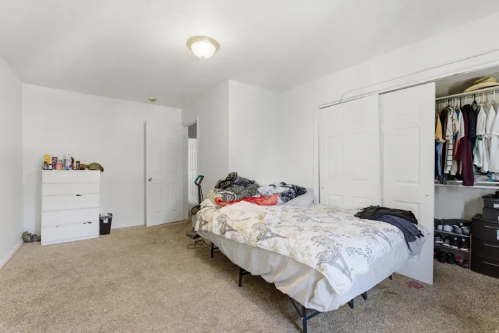 Bedroom with a closet and light colored carpet