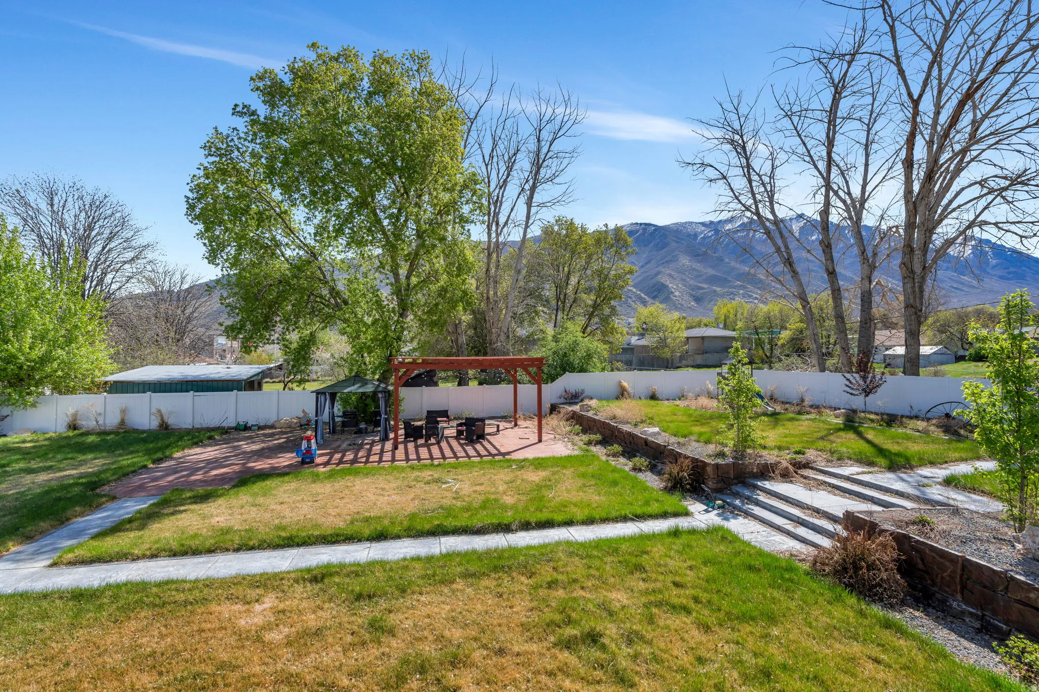Fenced backyard with a patio, a pergola, and a mountain view