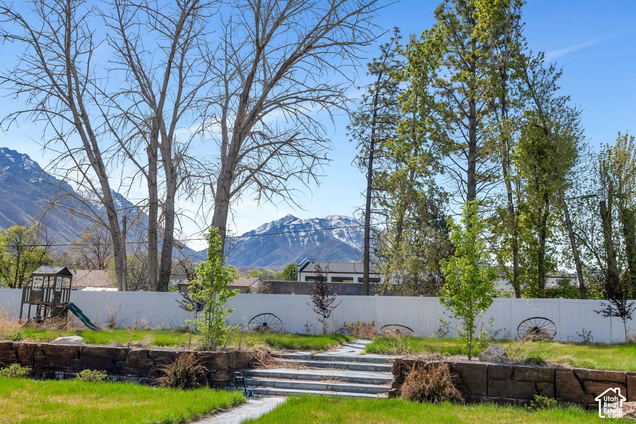 Fenced backyard with a mountain view and a playground