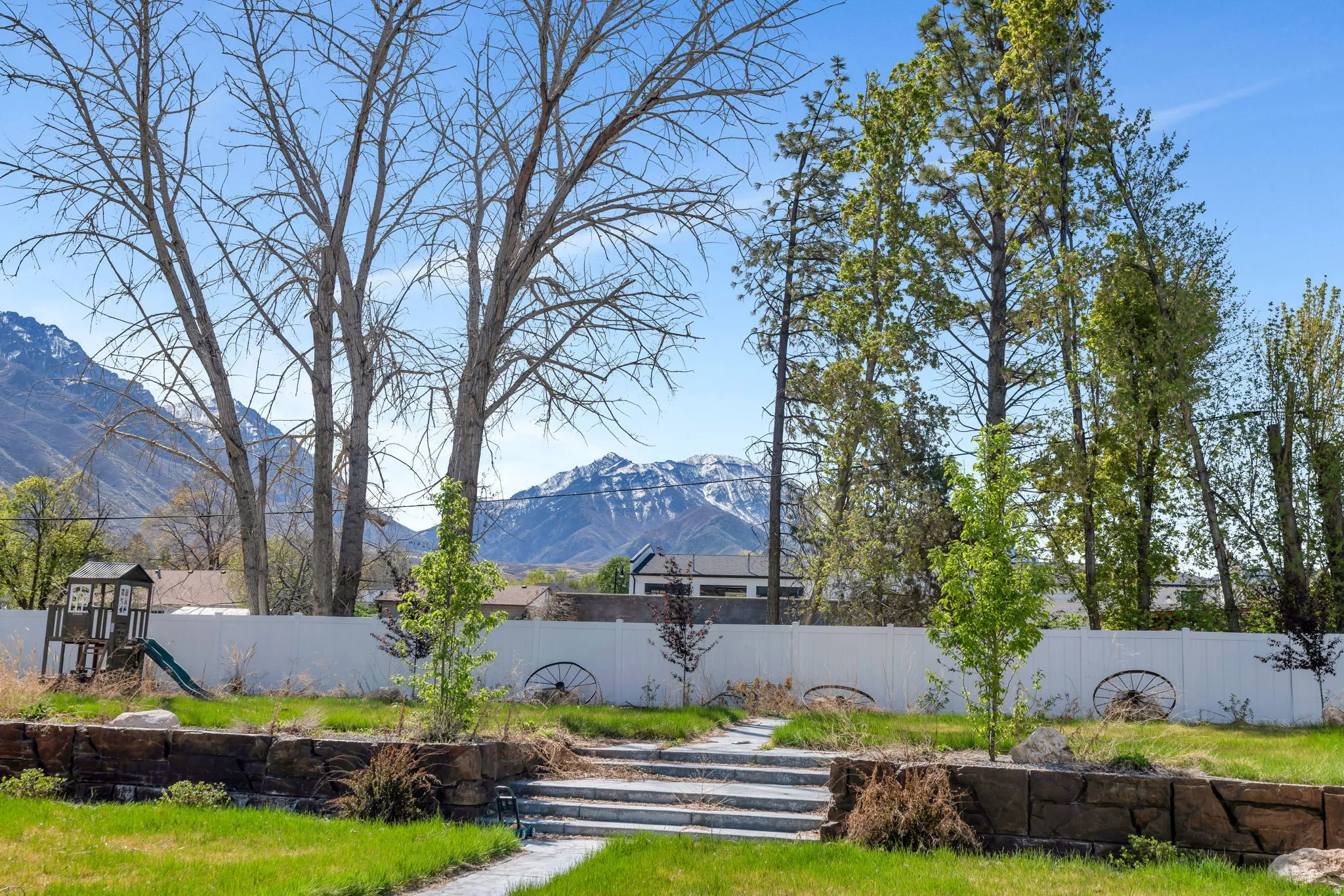 Fenced backyard with a mountain view and a playground