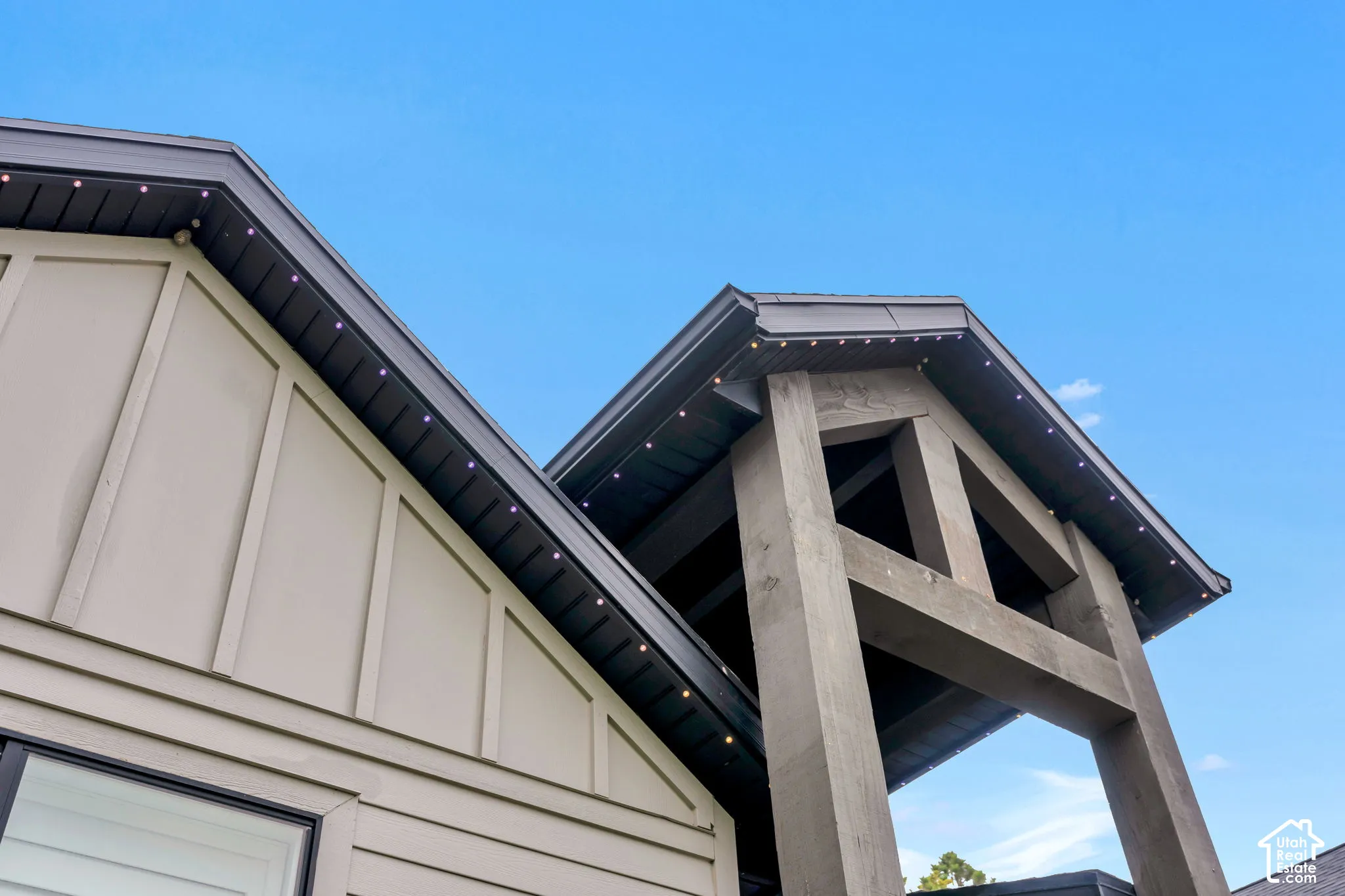 Exterior featuring board-and-batten siding, heavy timber structural truss, and integrated soffit lighting