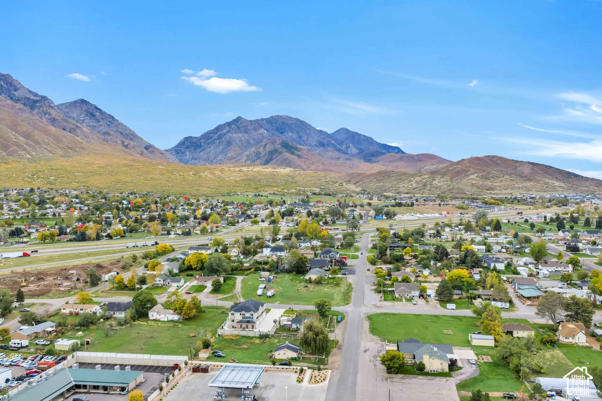 Aerial perspective showcasing expansive terrain, mature trees, and prominent mountain backdrops