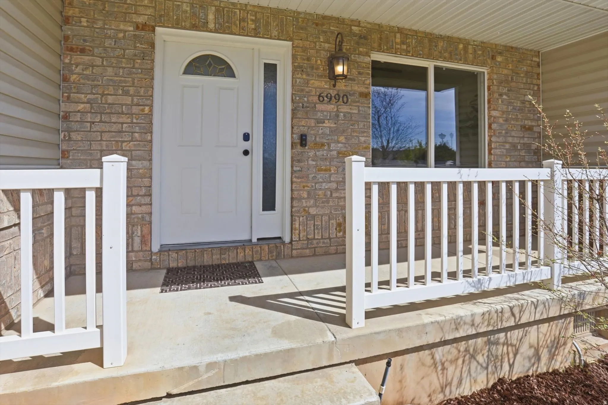 View of exterior entry with a porch and stone siding