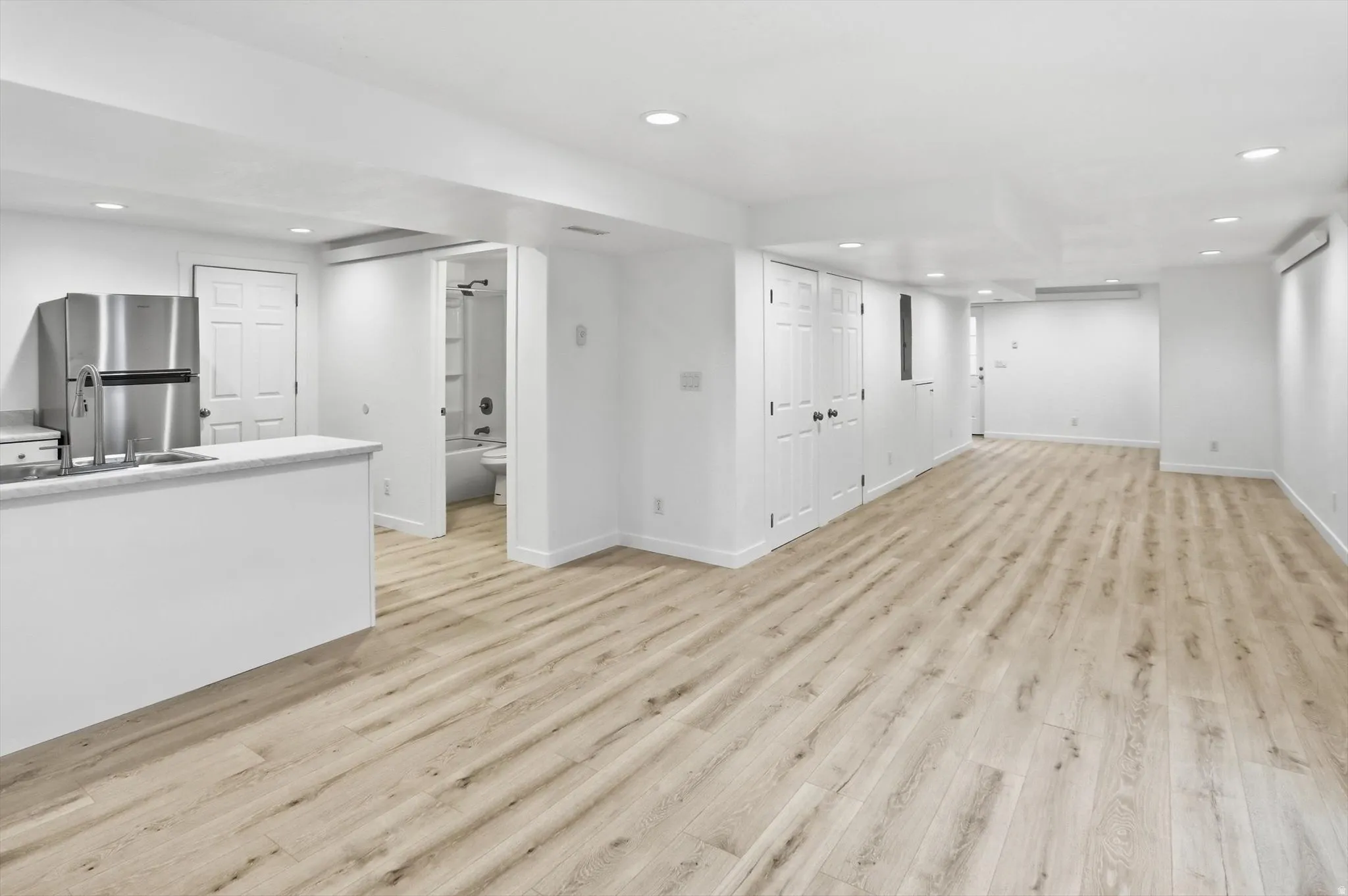 Unfurnished basement living room featuring recessed lighting and light wood-style flooring