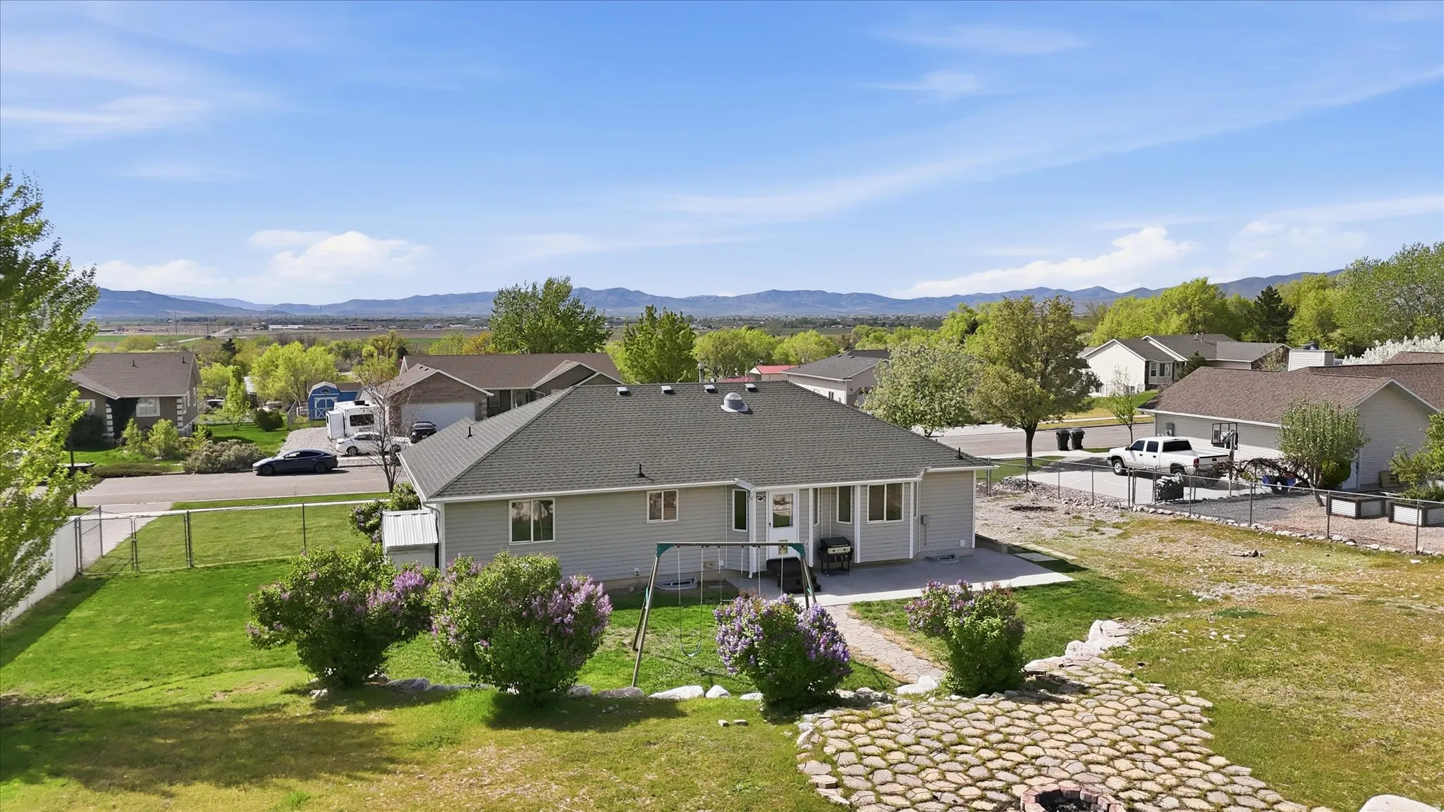 Rear view of house featuring a patio, a residential view, roof with shingles, and a fenced backyard
