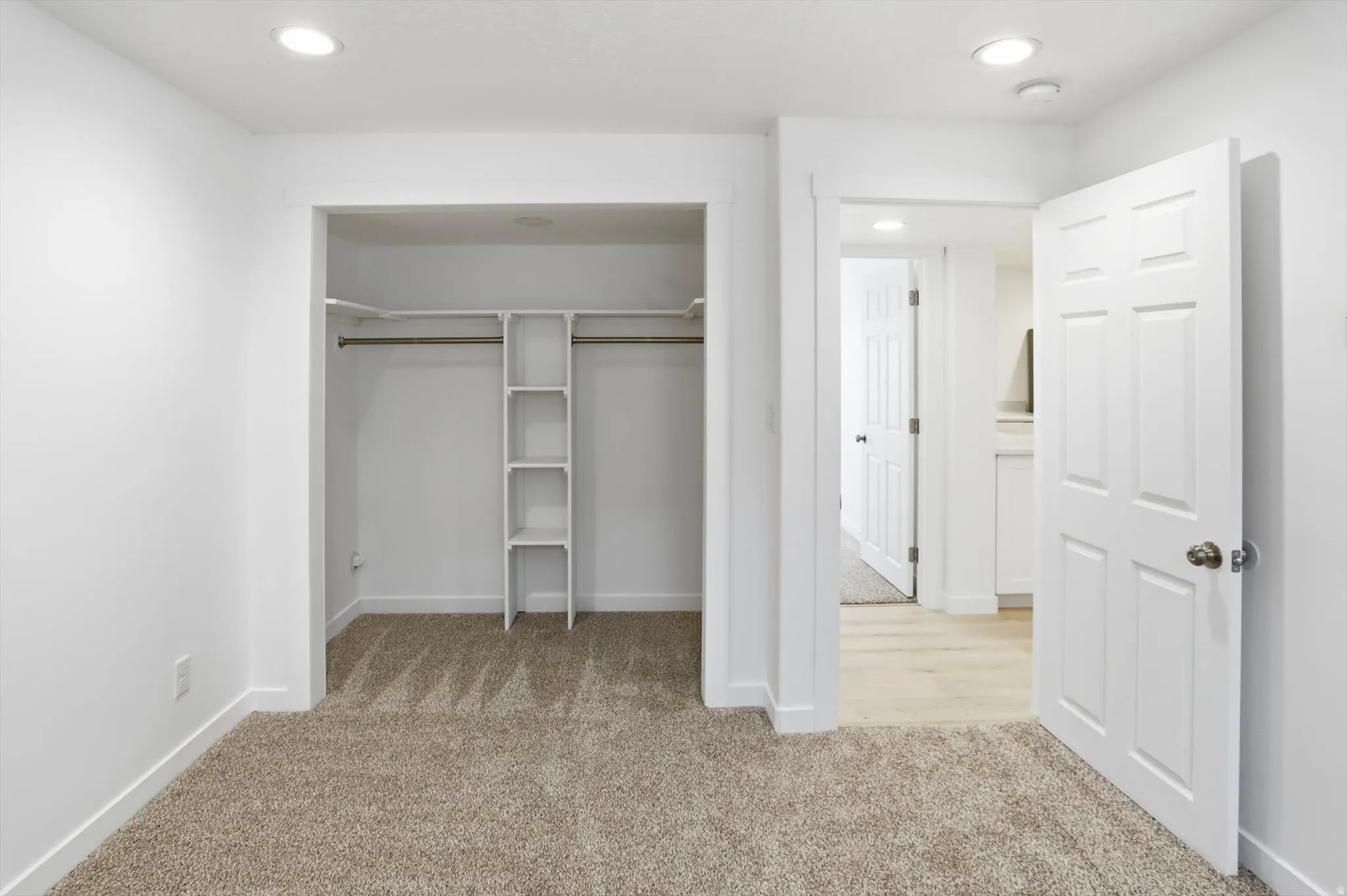 Unfurnished bedroom featuring light carpet, a closet, and recessed lighting