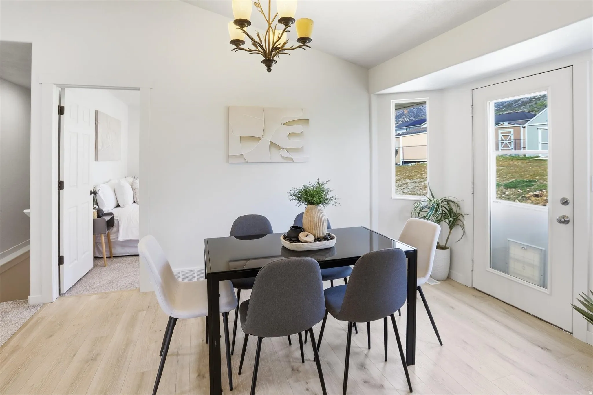 Dining space featuring a chandelier, lofted ceiling, and light wood-style flooring
