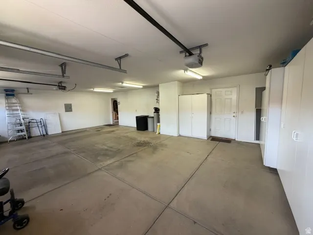Garage featuring electric panel and a garage door opener