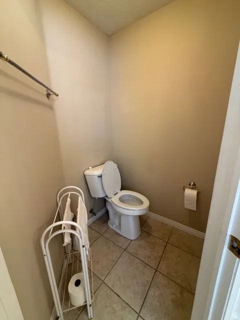 Bathroom featuring light tile patterned floors and a textured ceiling