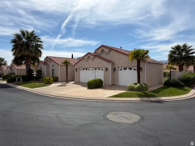 Mediterranean / spanish-style house featuring a garage, concrete driveway, and stucco siding