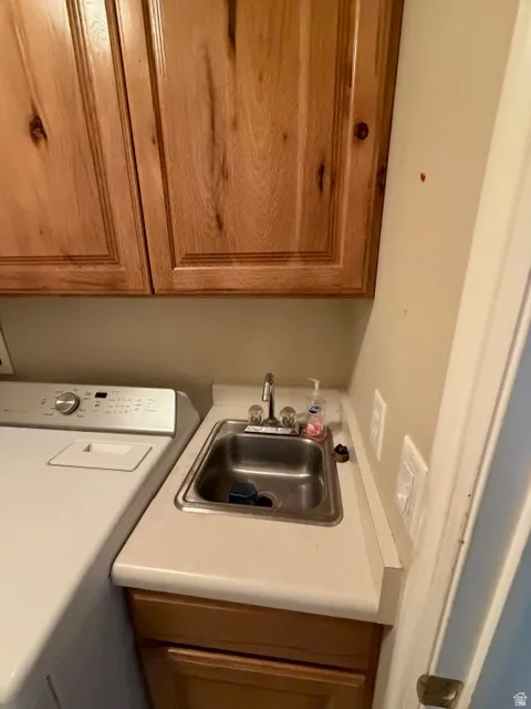 Laundry area featuring washer / clothes dryer and a sink