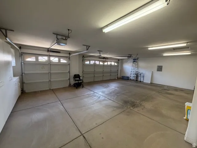 Garage featuring a garage door opener and electric panel
