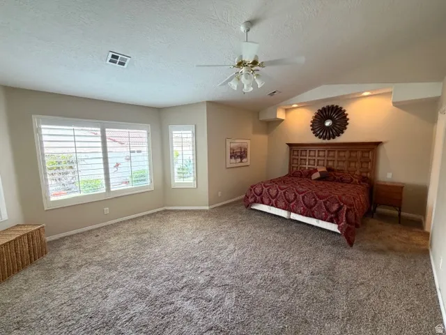 Carpeted bedroom with a ceiling fan and baseboards
