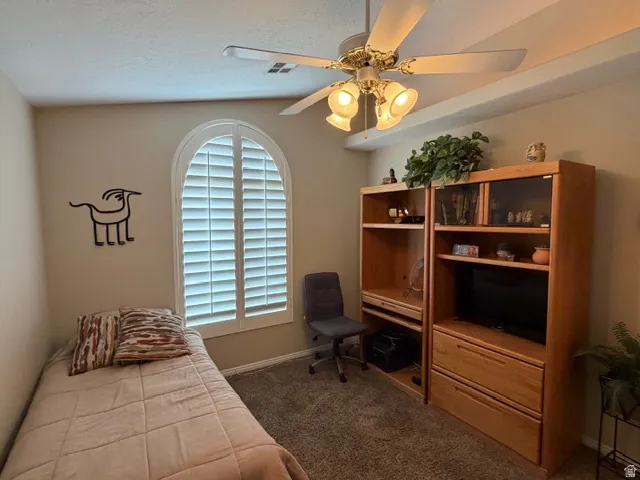 Bedroom featuring dark carpet and ceiling fan