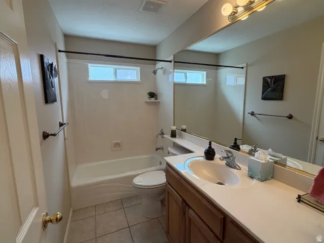 Bathroom with vanity, light tile patterned floors, and bathtub / shower combination