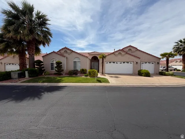 Mediterranean / spanish-style home with stucco siding, a garage, concrete driveway, and a front lawn