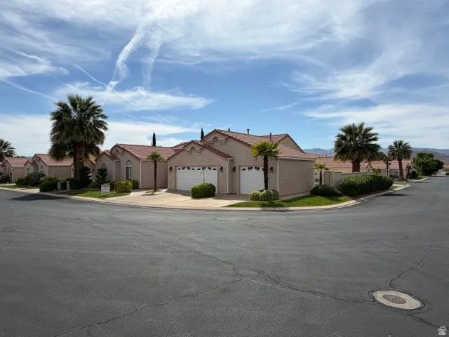 View of front facade featuring a garage, a residential view, stucco siding, and concrete driveway