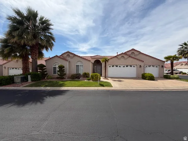 Mediterranean / spanish-style house with an attached garage, stucco siding, concrete driveway, and a front yard