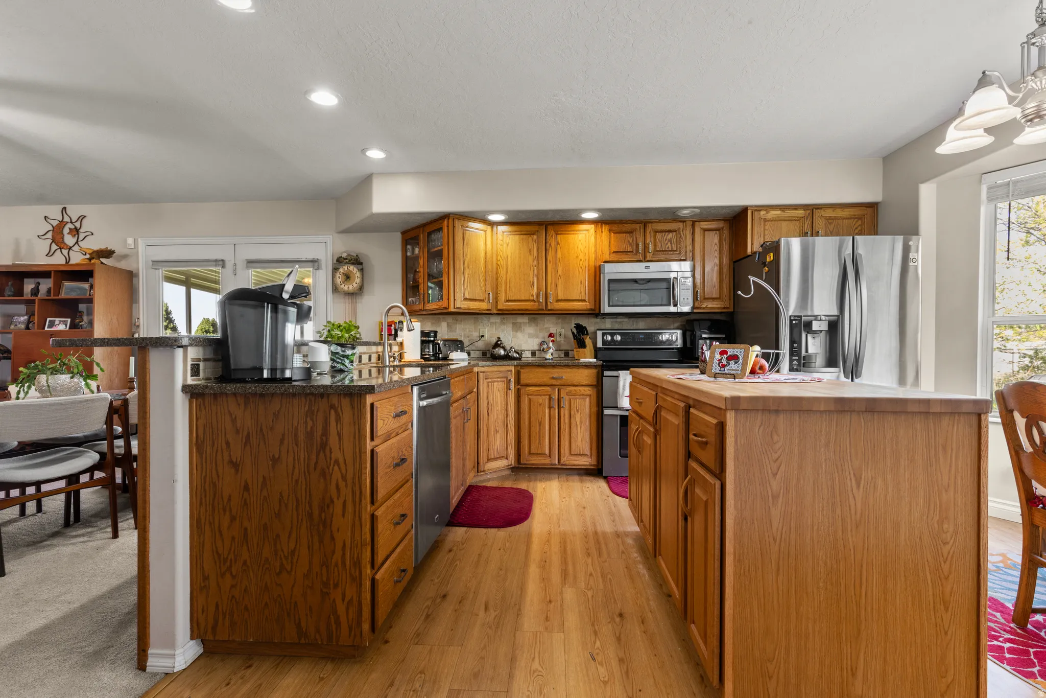 Kitchen with wood finish cabinetry, stainless steel appliances, a kitchen island, light wood-style floors, and plenty of natural light