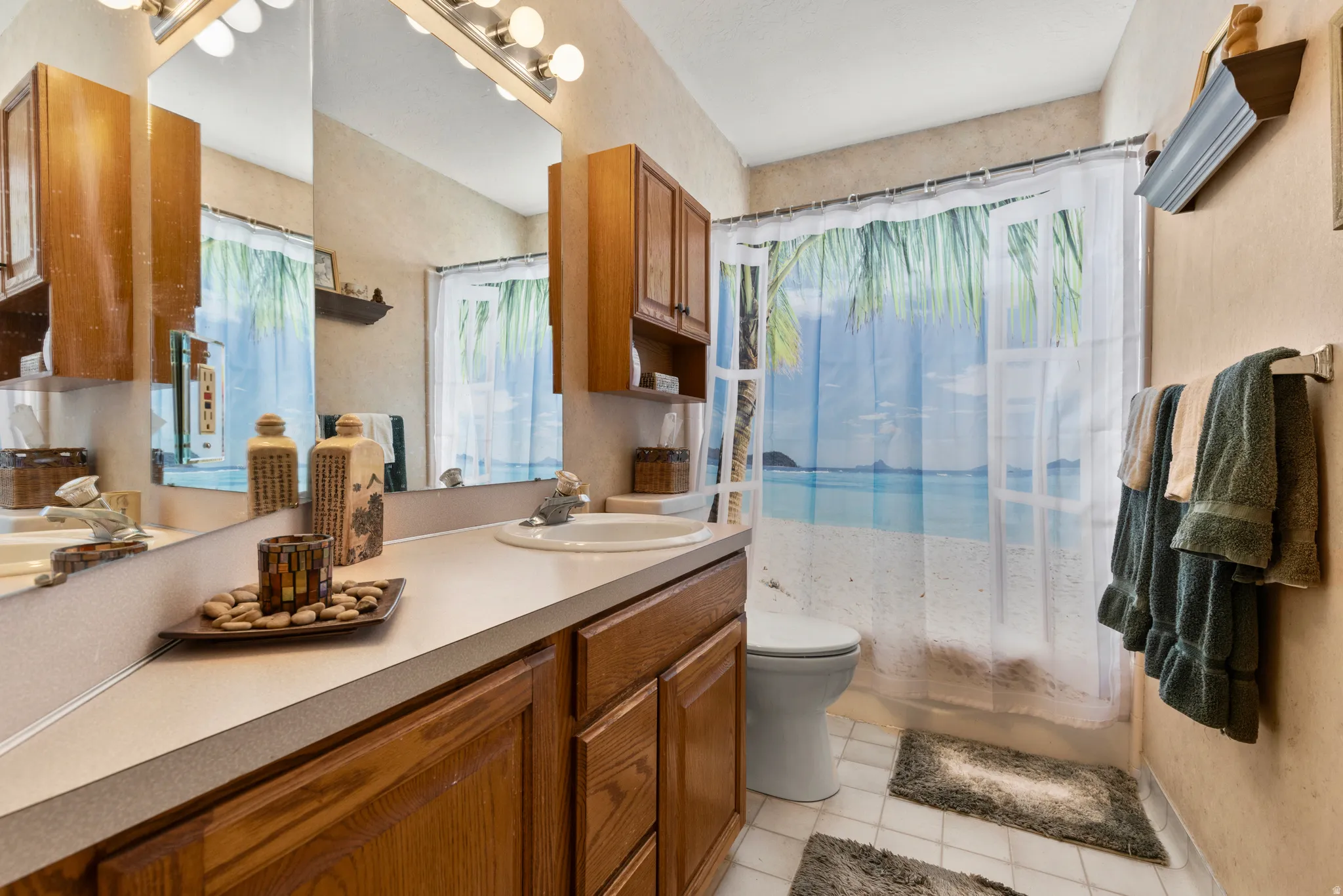 Bathroom with vanity, shower / bath combo, and light tile patterned floors