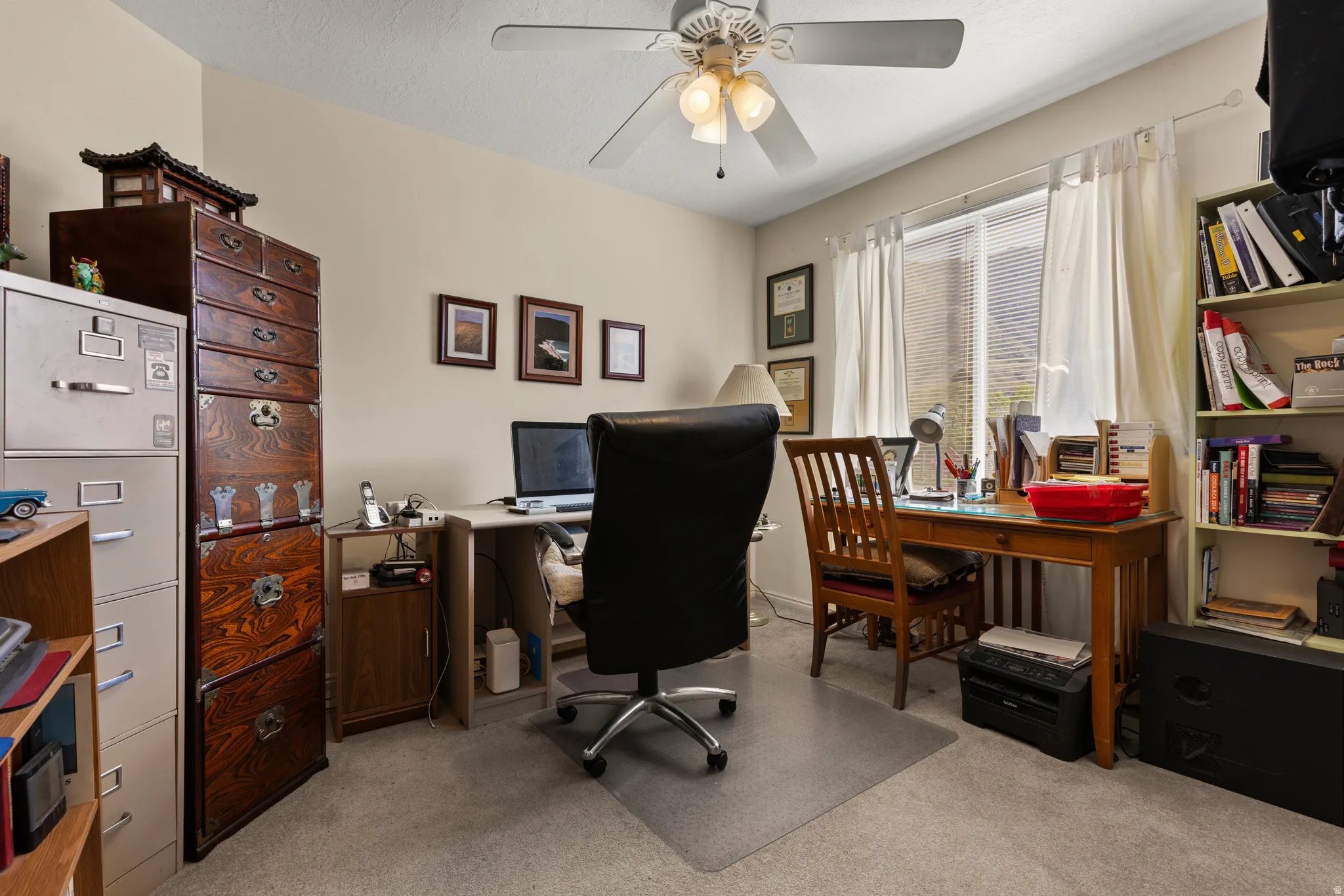 Office area with light colored carpet and a ceiling fan