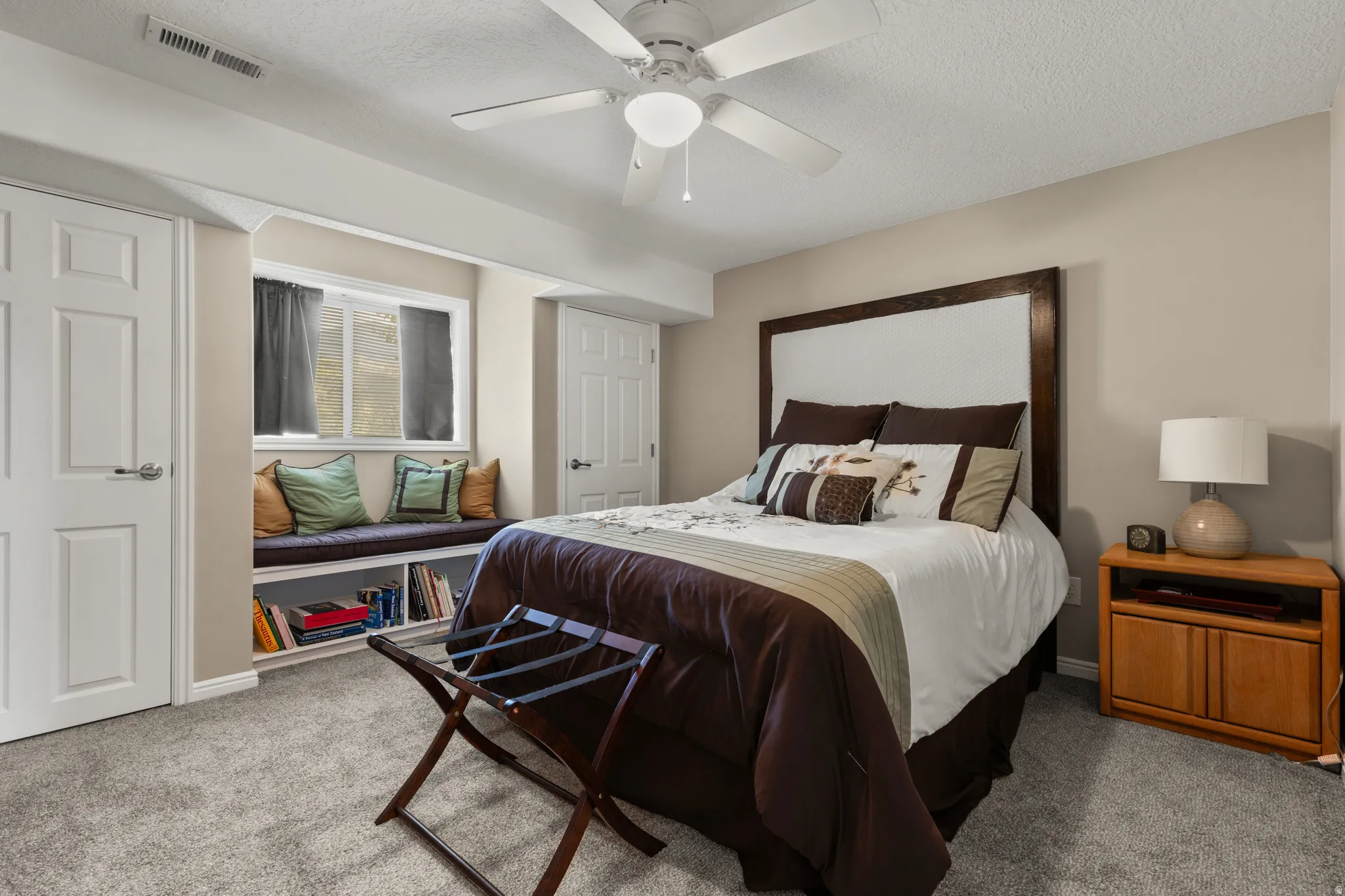 Bedroom with carpet, a textured ceiling, and ceiling fan