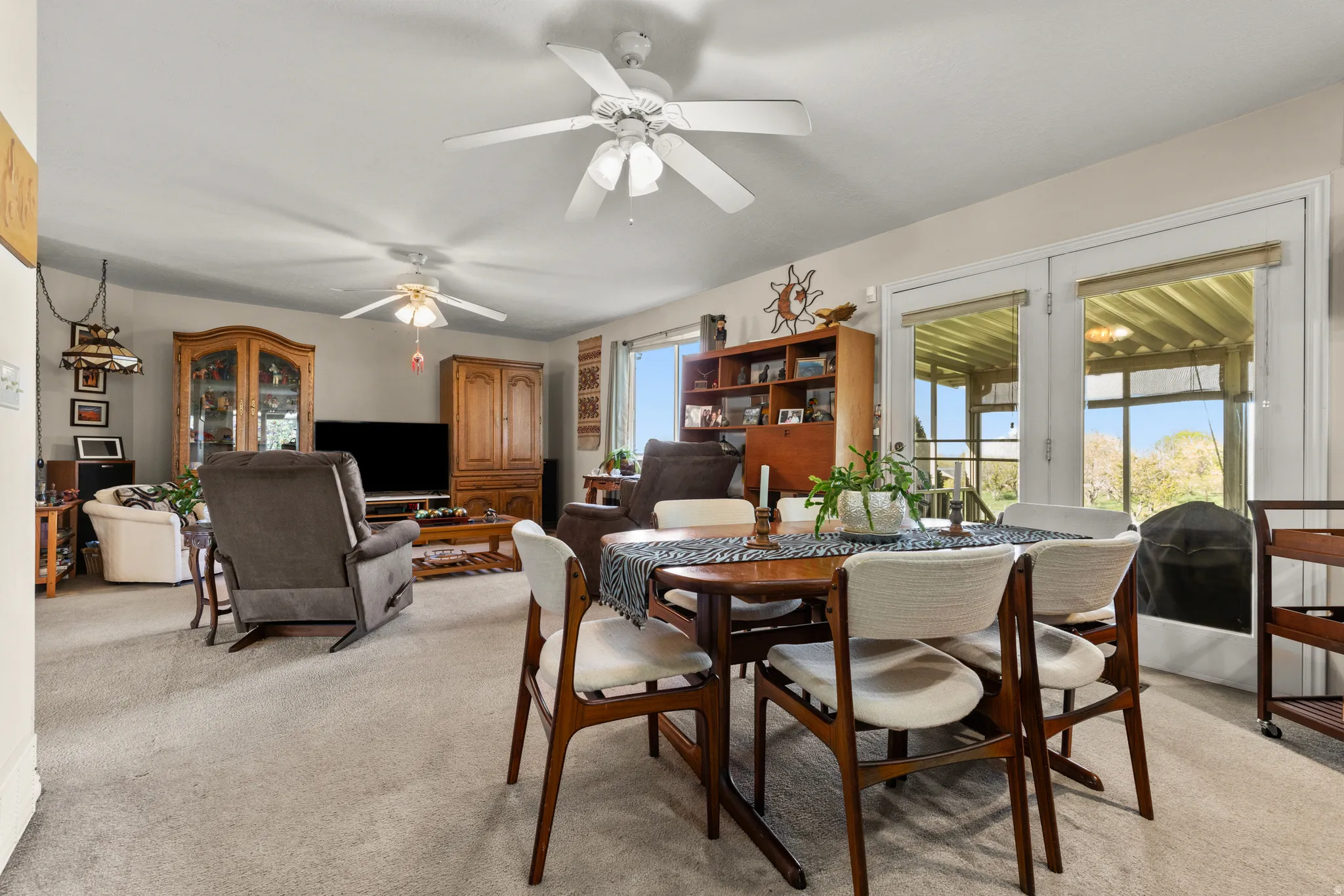 Dining space featuring light carpet and ceiling fan