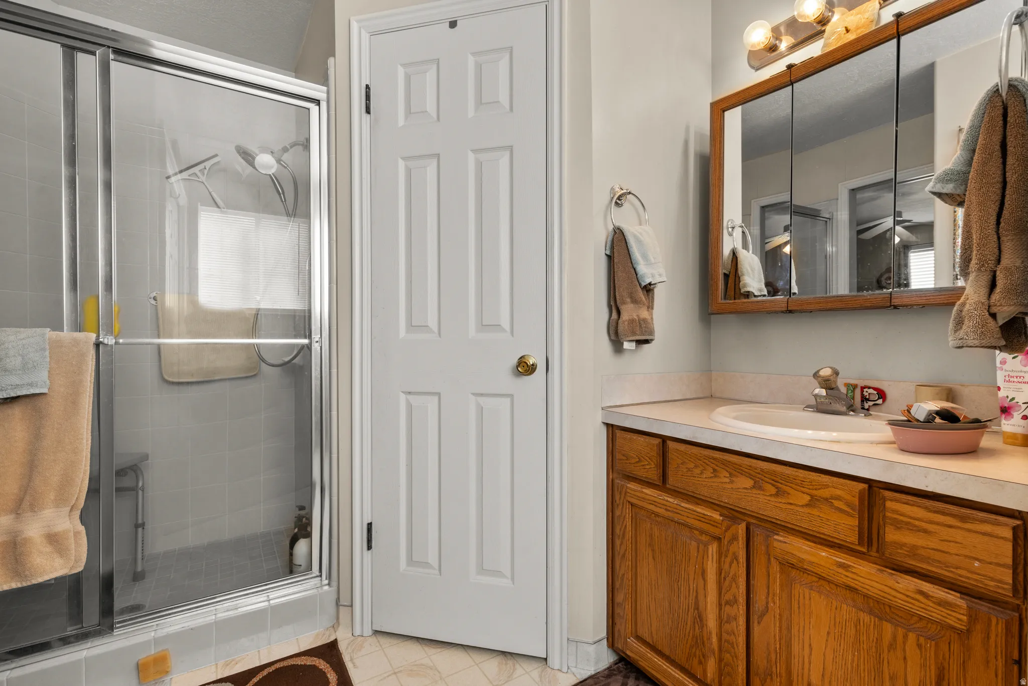 Bathroom featuring vanity, a stall shower, and light tile patterned floors