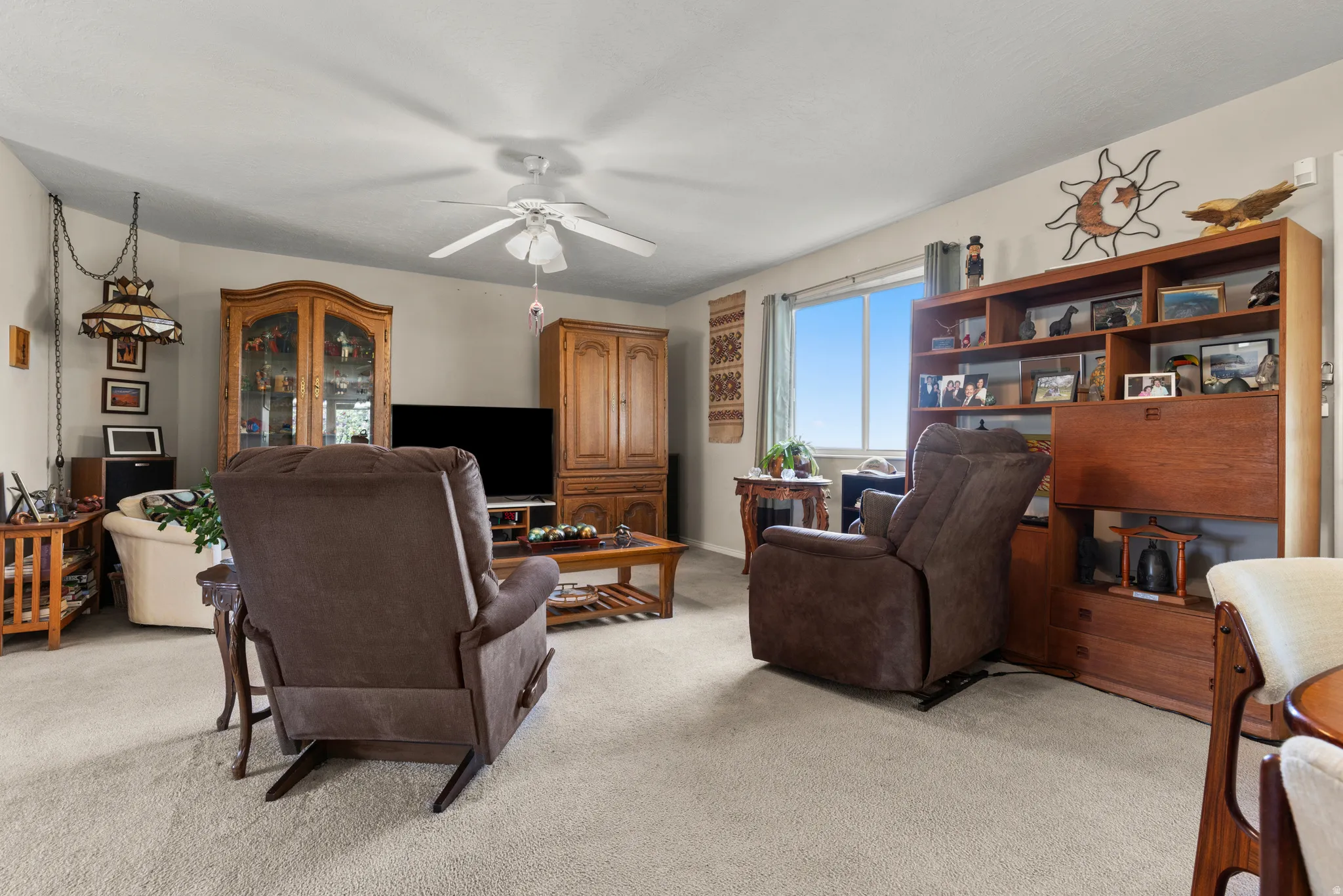 Living room with light carpet and a ceiling fan