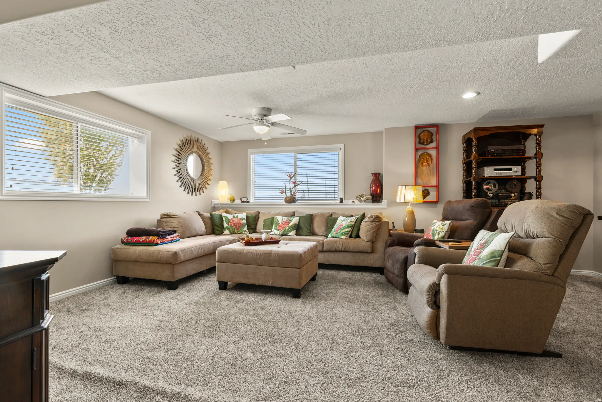 Carpeted living room with a textured ceiling, a ceiling fan, and recessed lighting