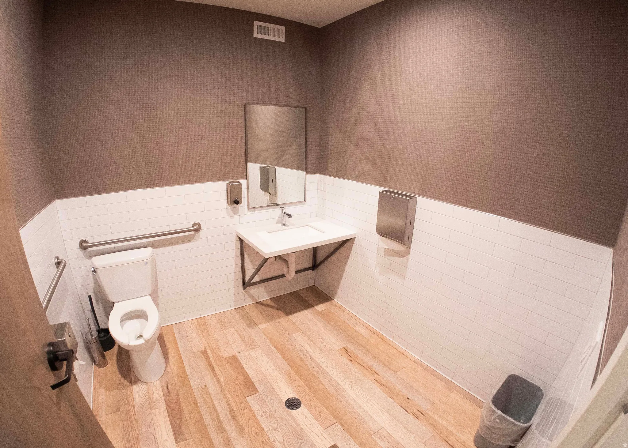 Bathroom featuring tile walls, a wainscoted wall, vanity, and light wood finished floors