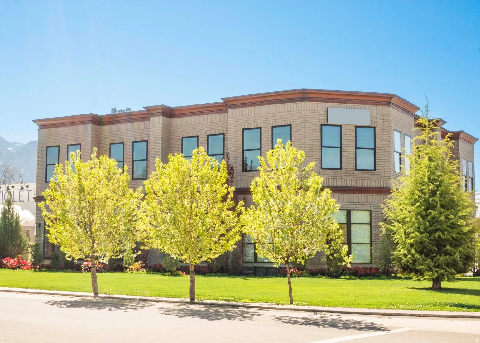 Multi-story commercial building featuring light-colored brick construction and dark-framed windows