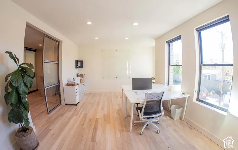 Office area featuring light wood-style floors and recessed lighting