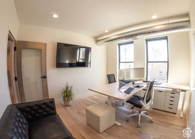 Home office with wood finished floors and recessed lighting